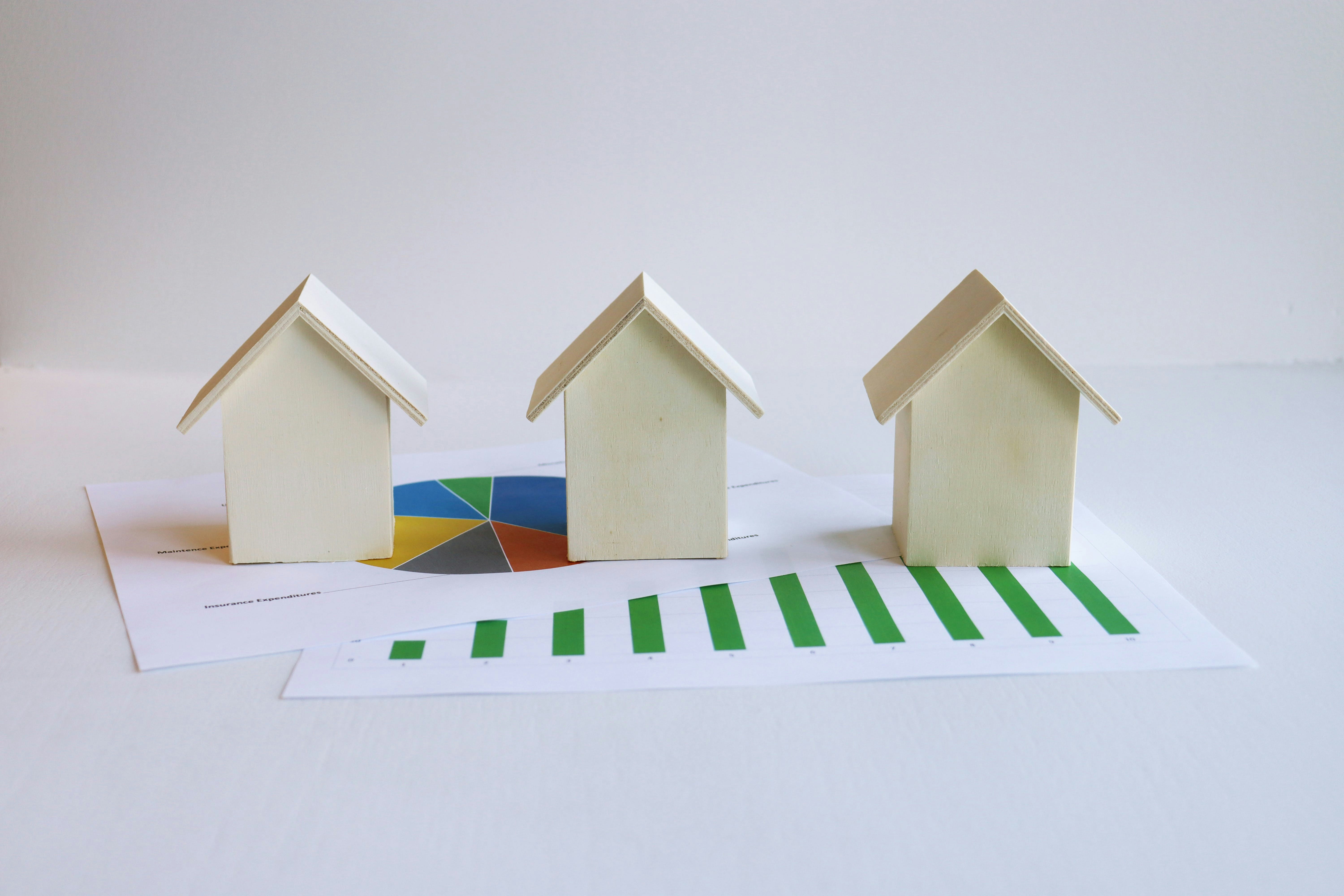 Property investment concept with house models and growth charts for comparing Sydney suburbs with capital growth potential