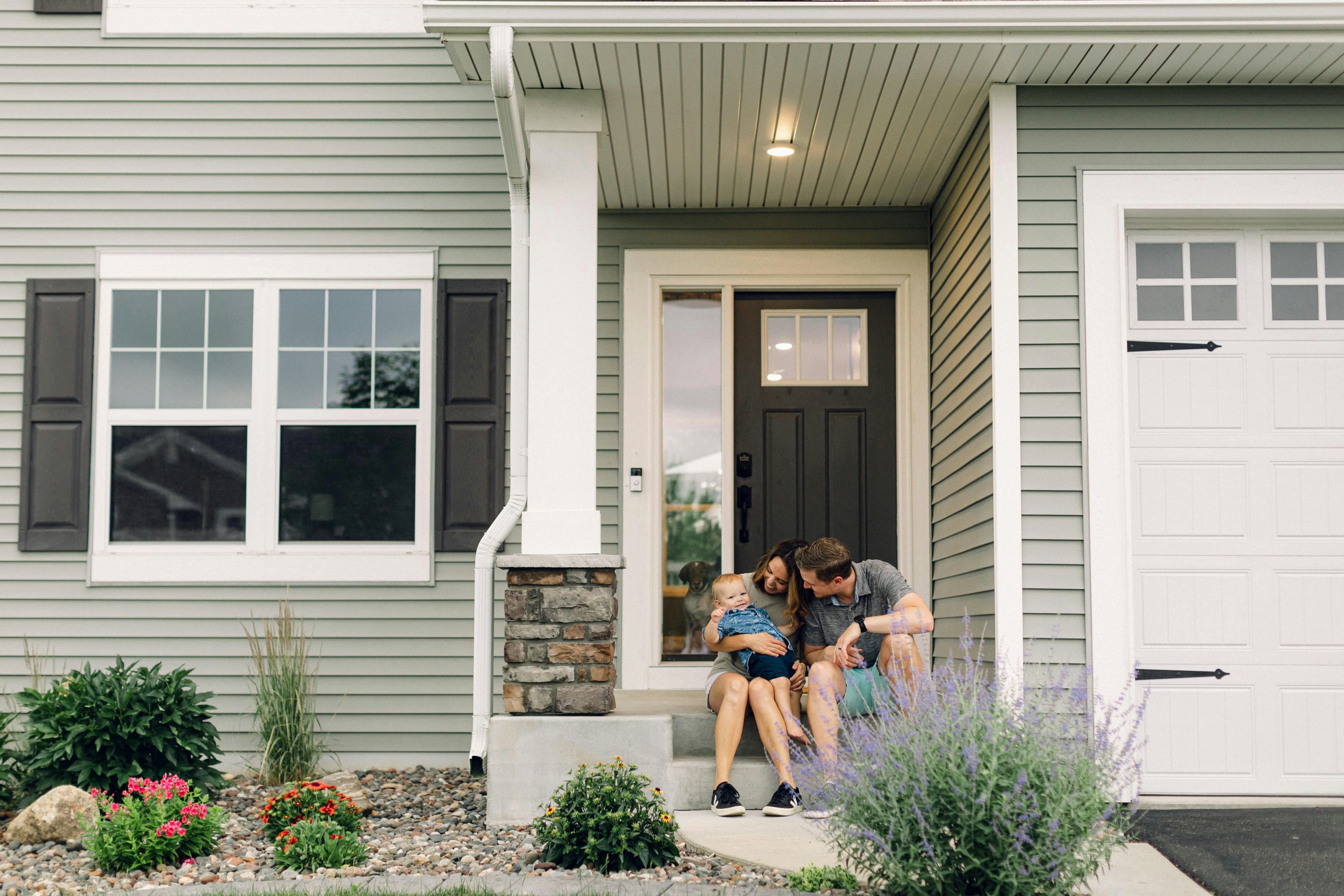 Family sitting outside a home after purchase representing confident Sydney buyers completing property inspection and settlement