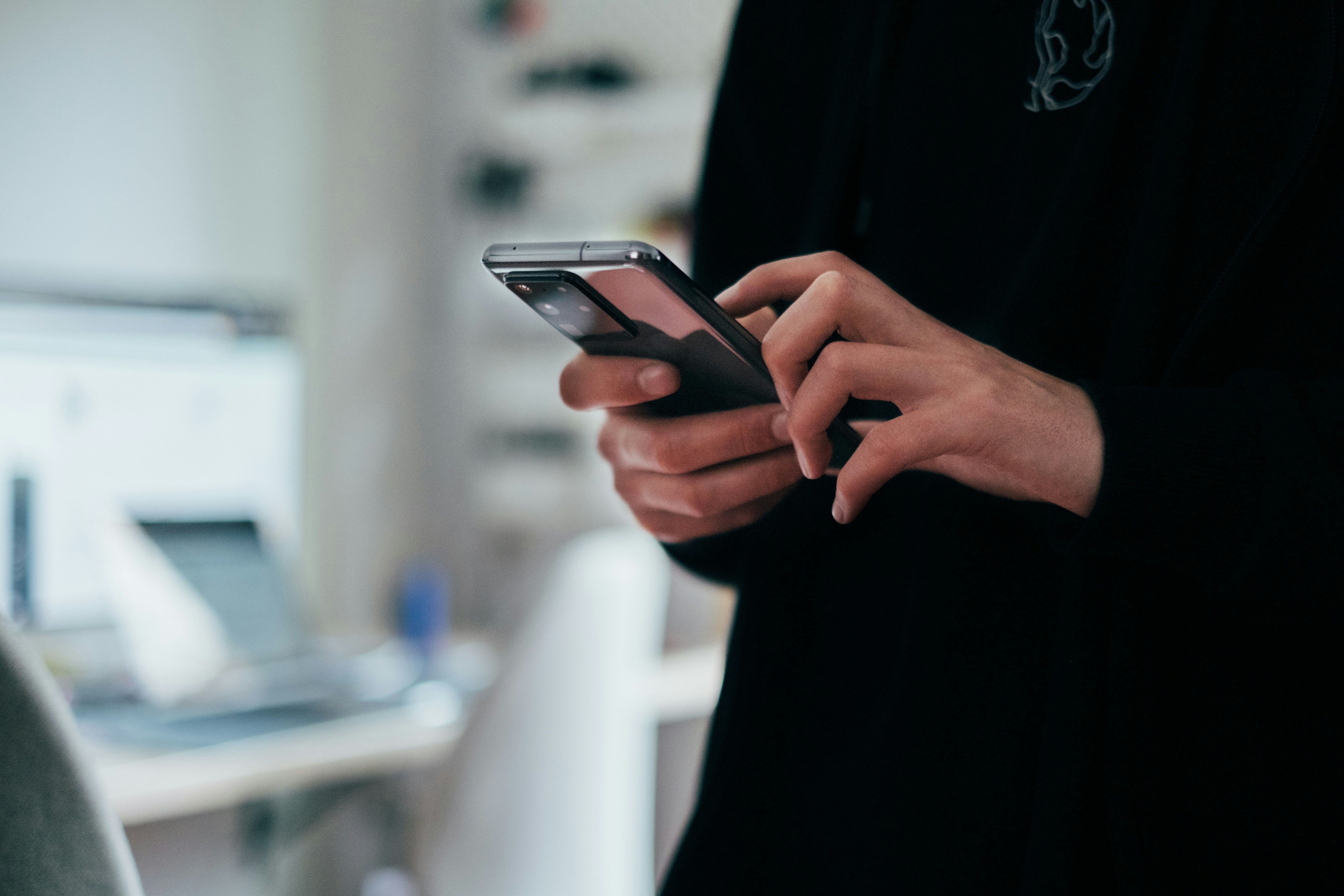 Home buyer using a smartphone during a property inspection to record notes, photos and digital checklist items