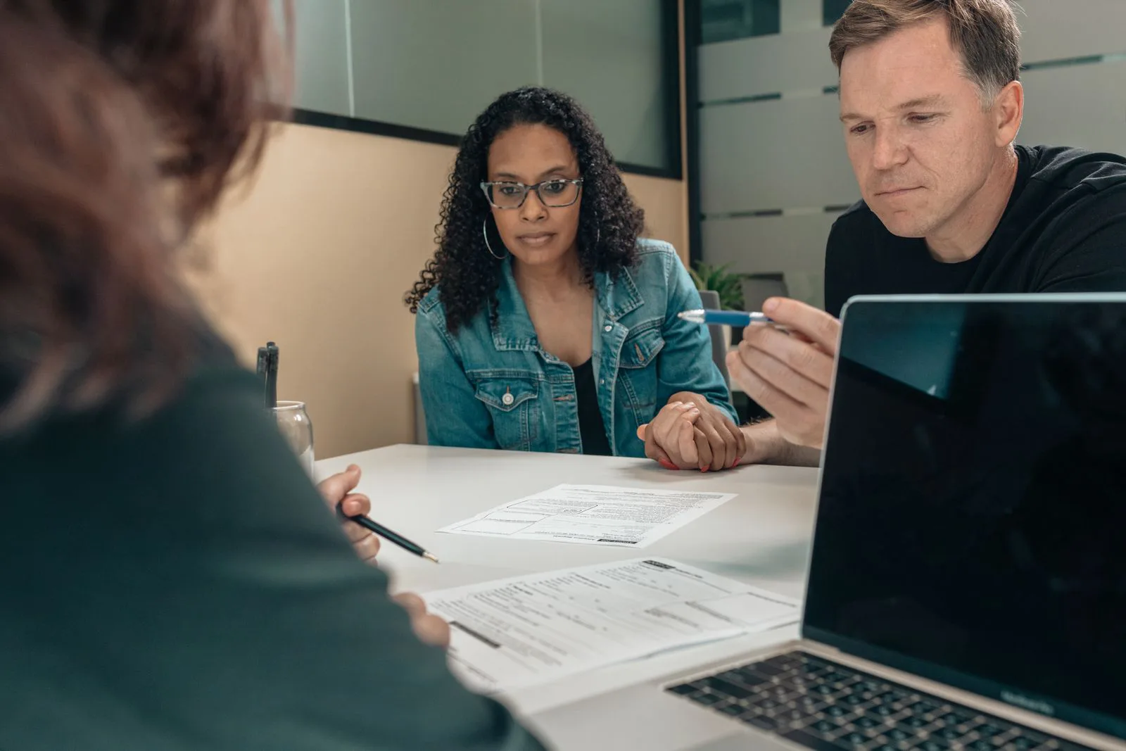 A home buyer and a mortgage broker sitting at a desk reviewing loan documents together