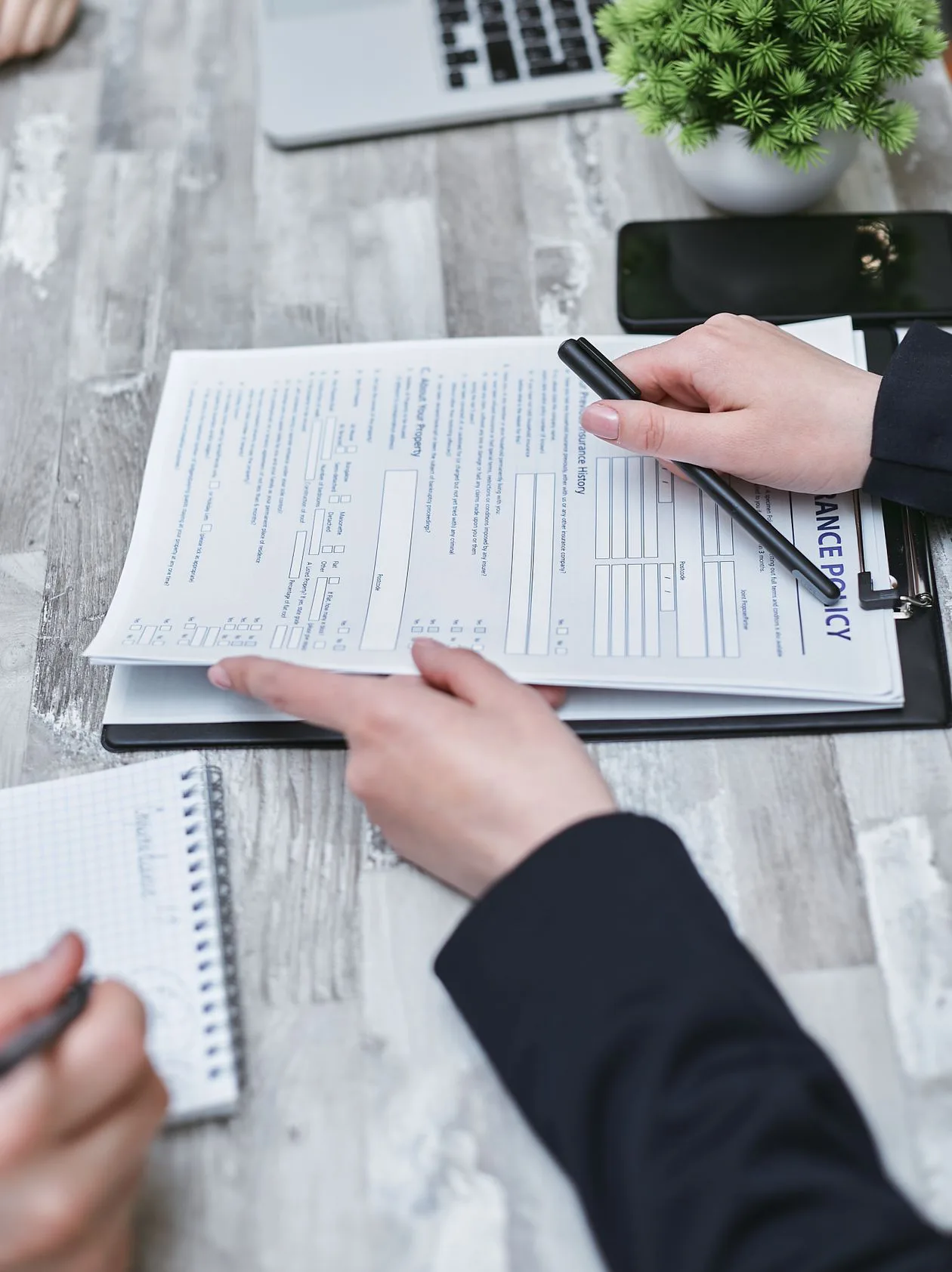 Close-up of hands reviewing official superannuation and property paperwork, the fund rules that govern an SMSF residential investment